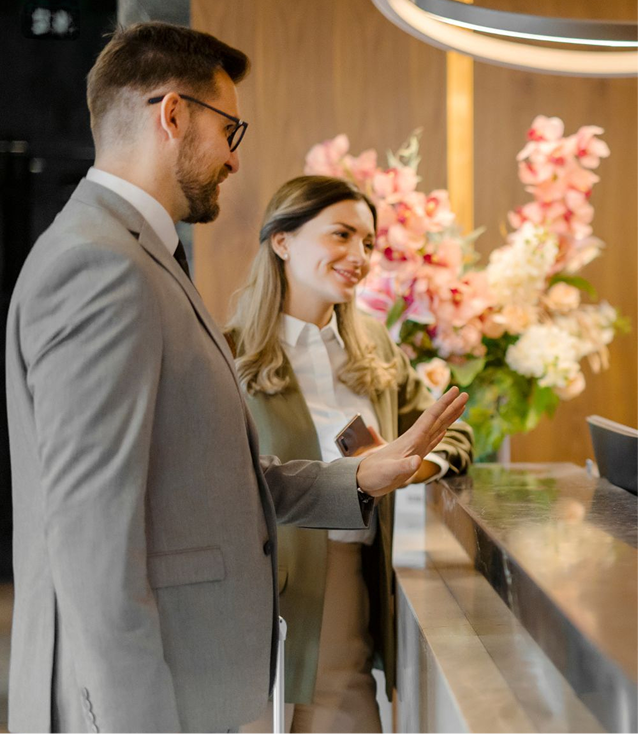 Couple checking in with a receptionist at a modern hotel front desk